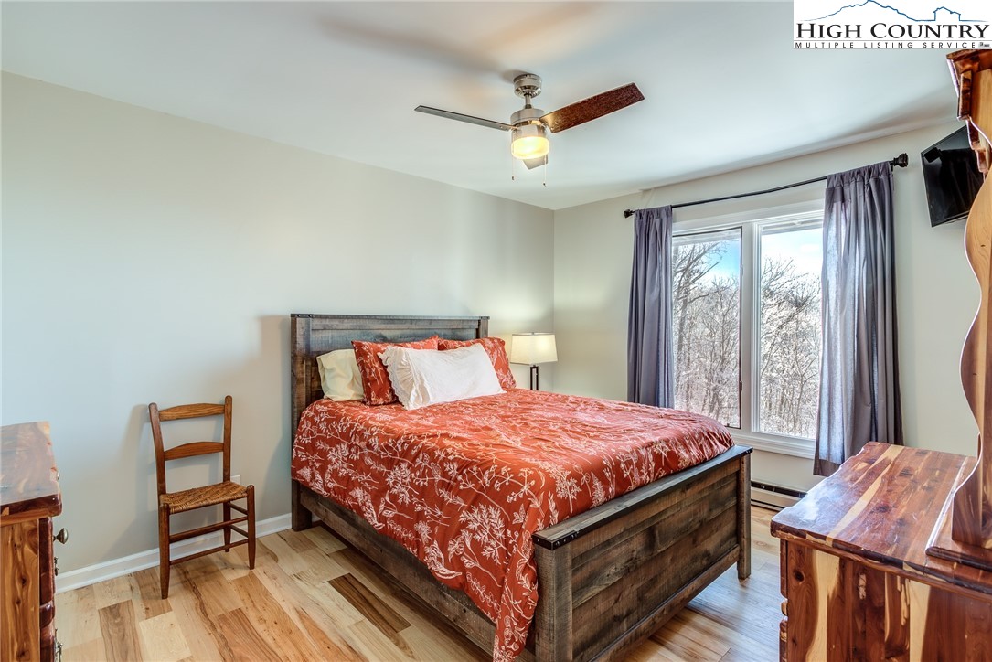 523 Pine Ridge Road Beech Mountain, NC 28604 - Photo 25 of 42 a bedroom with a bed and a chandelier