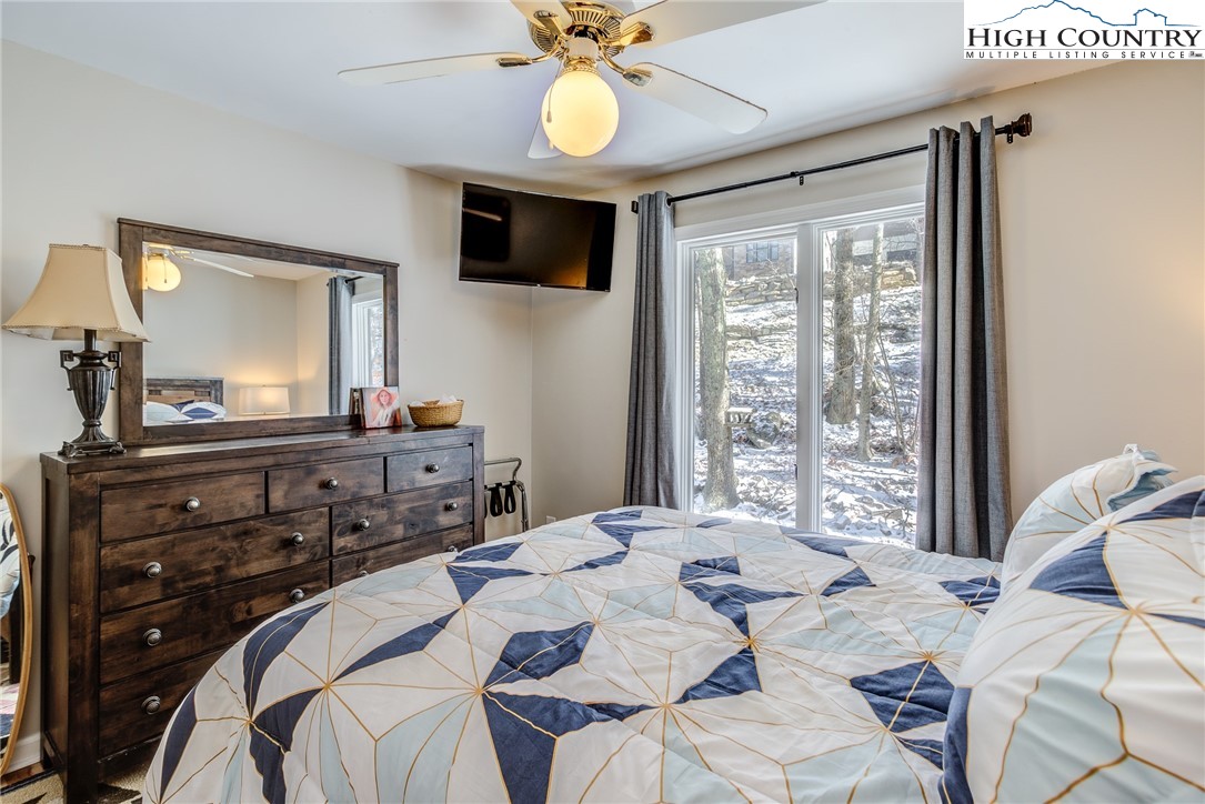 523 Pine Ridge Road Beech Mountain, NC 28604 - Photo 28 of 42 a bedroom with a bed and a chandelier