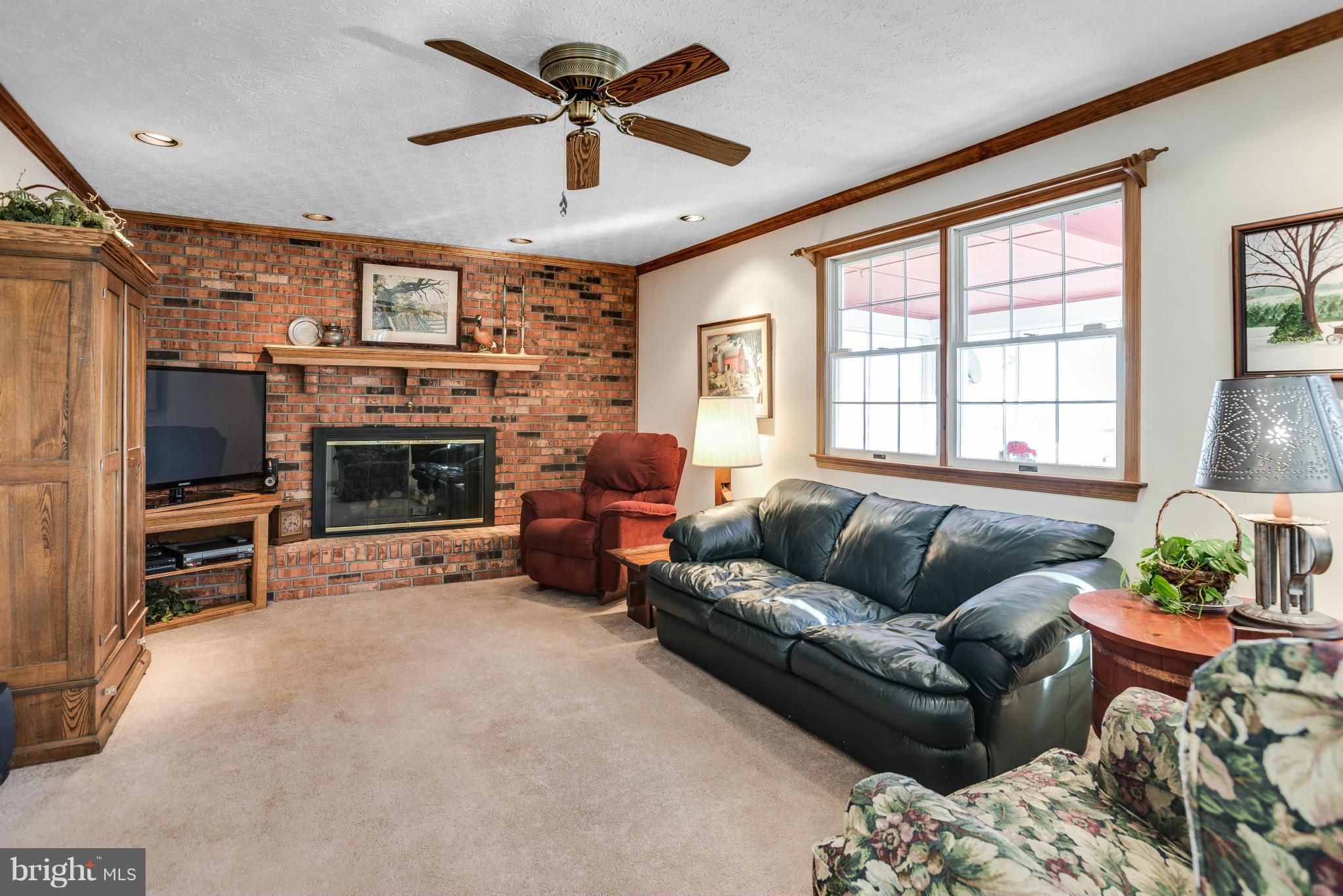 19003 Graystone Road White Hall, MD 21161 - Photo 5 of 21 a living room with furniture a fireplace and a flat screen tv