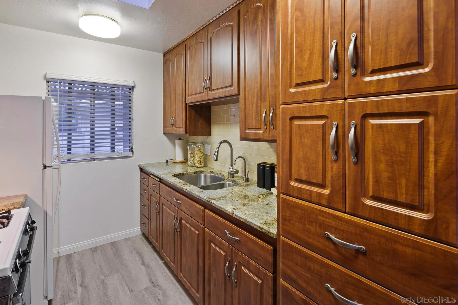 916 Crest Drive Encinitas, CA 92024 - Photo 23 of 47 a kitchen with granite countertop cabinets stainless steel appliances a sink and wooden floor