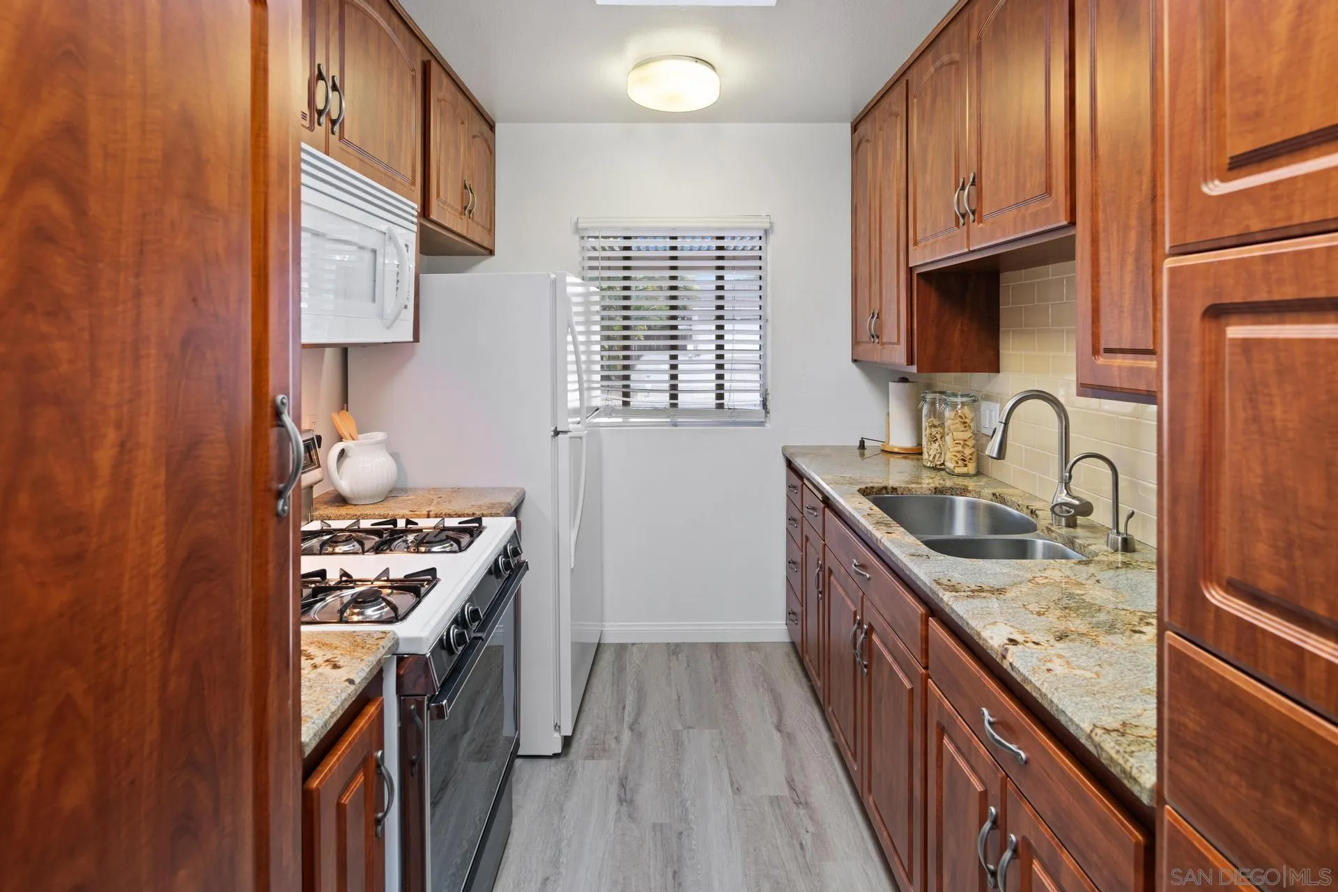 916 Crest Drive Encinitas, CA 92024 - Photo 25 of 47 a kitchen with granite countertop a sink stove and cabinets