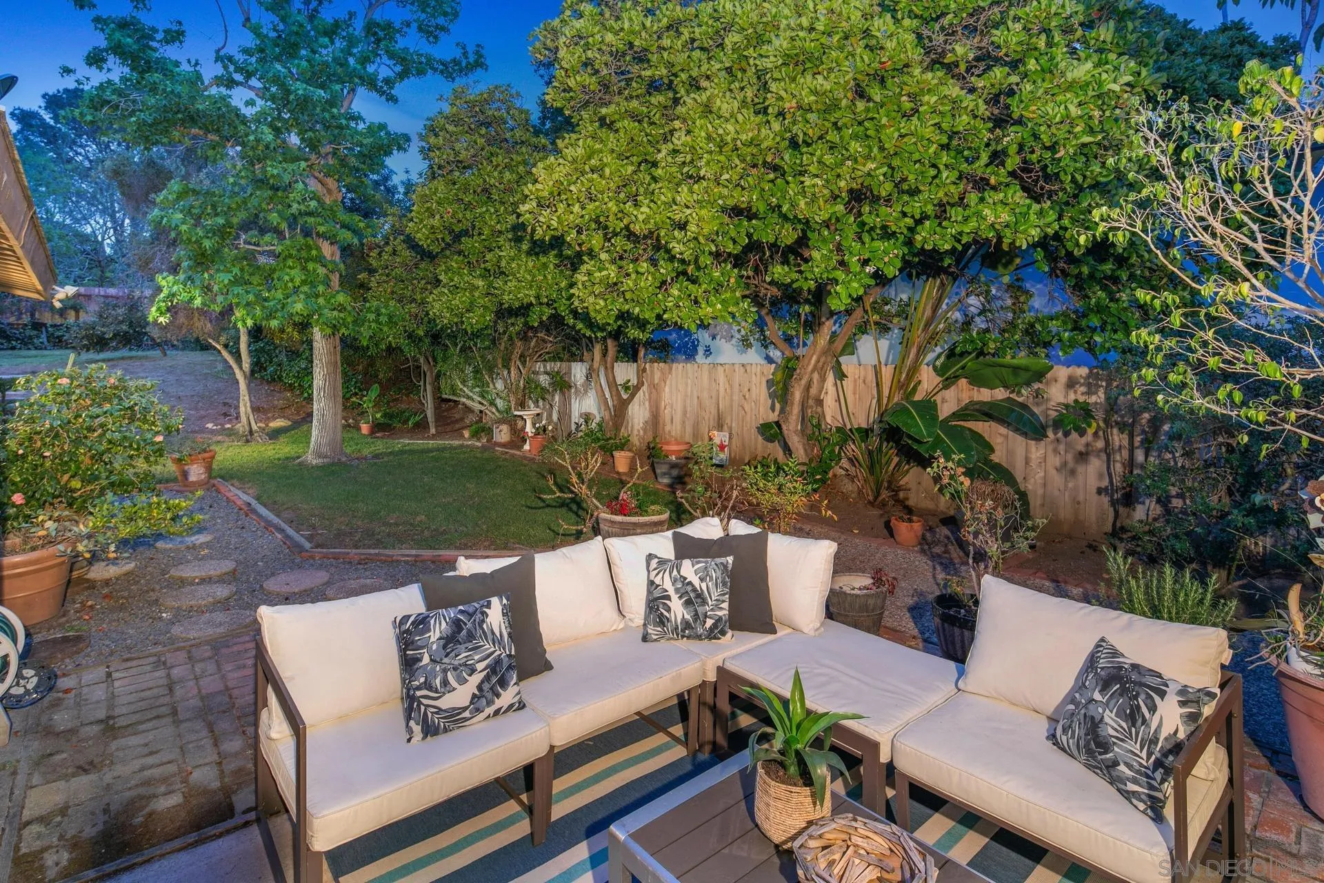 916 Crest Drive Encinitas, CA 92024 - Photo 8 of 47 a view of a patio with couches and a table and chairs with plants and trees