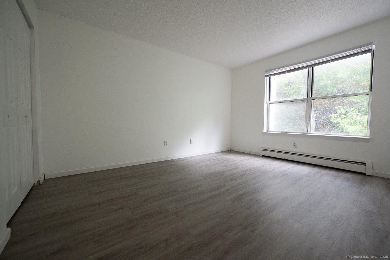 346 Forbes Avenue, Unit 346 New Haven, CT 06512 - Photo 7 of 15 an empty room with wooden floor and windows