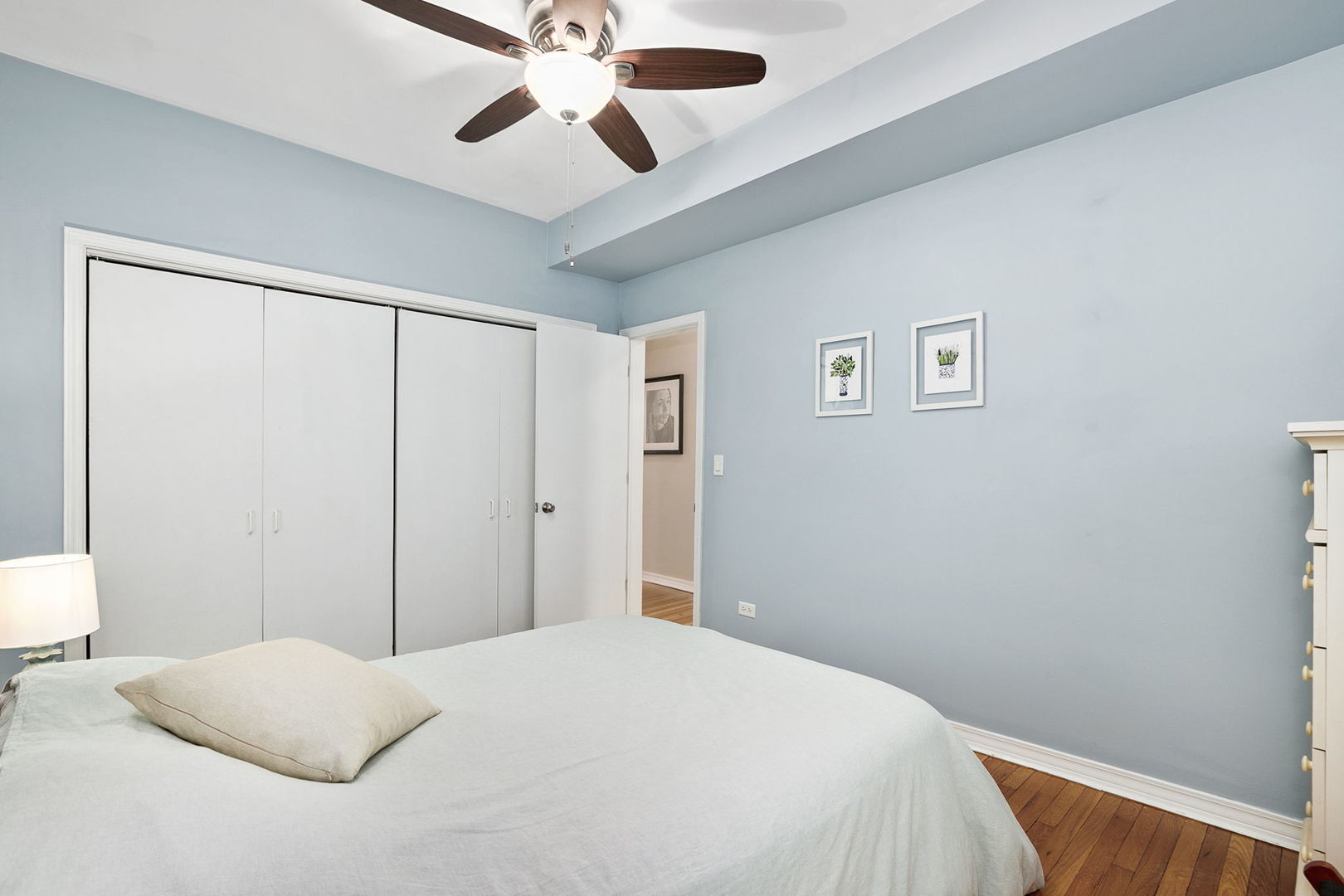 4429 North Beacon Street, Unit 2N Chicago, IL 60640 - Photo 23 of 32 a bedroom with a large bed and a chandelier