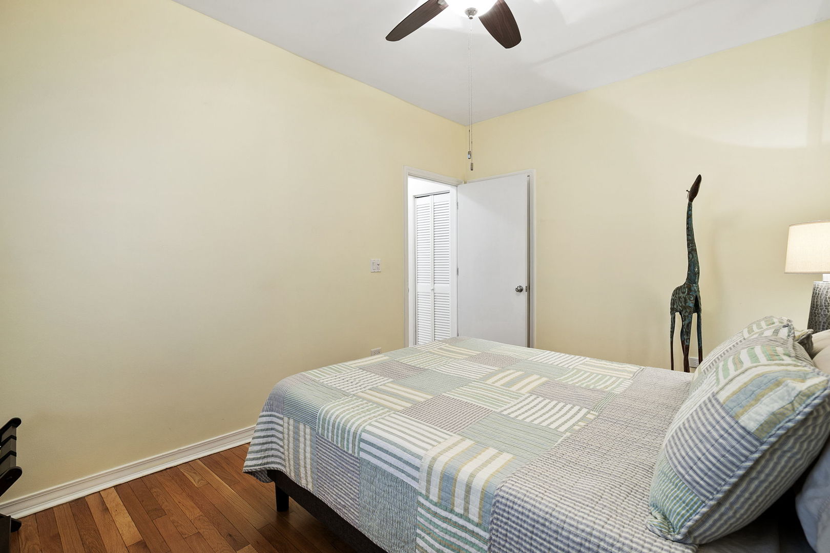 4429 North Beacon Street, Unit 2N Chicago, IL 60640 - Photo 25 of 32 a bedroom with a bed and a chandelier