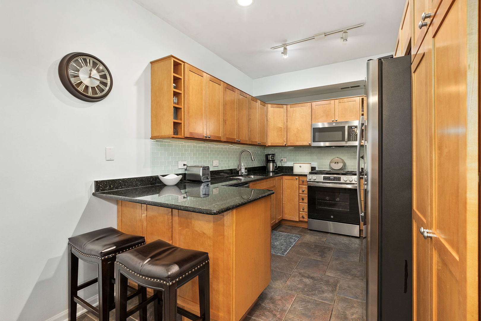 4429 North Beacon Street, Unit 2N Chicago, IL 60640 - Photo 10 of 32 a kitchen with stainless steel appliances granite countertop a stove and a refrigerator