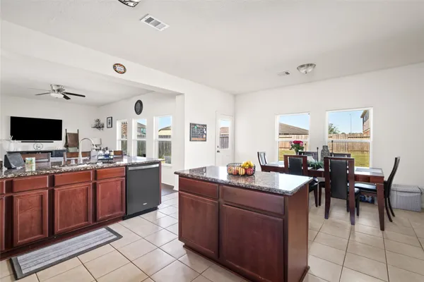 a dining hall with stainless steel appliances granite countertop a sink and dishwasher with a dining table