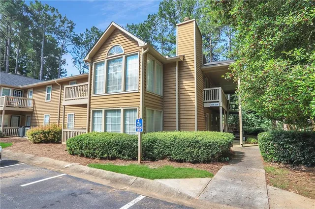a front view of a house with a yard and potted plants