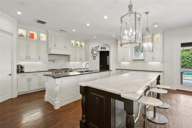 a kitchen with granite countertop a sink appliances and cabinets
