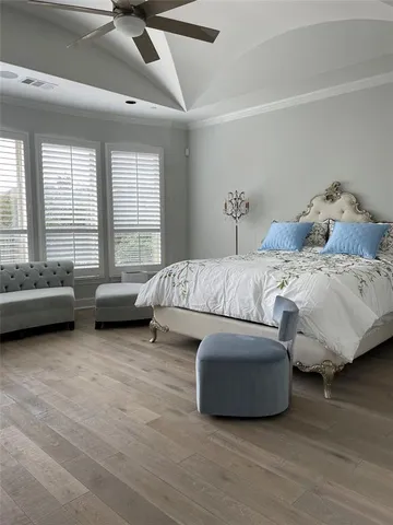 a spacious bedroom with a bed a couch and a large window