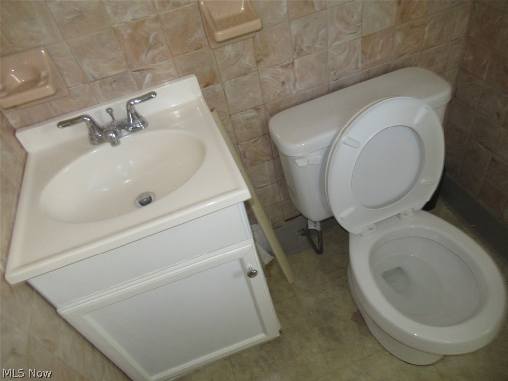 6033 Randy Road Bedford Heights, OH 44146 - Photo 19 of 19 Bathroom featuring a white vanity with an integrated sink, chrome faucet, and coordinating white toilet