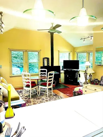 a living room with furniture a flat screen tv and floor to ceiling window