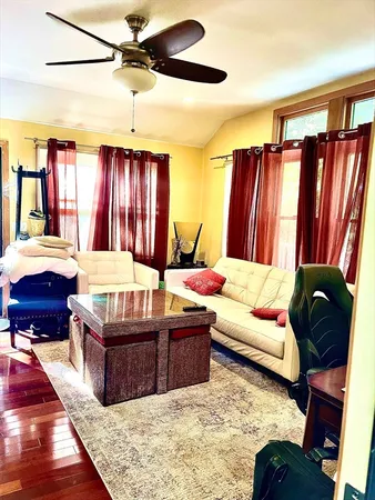 a living room with furniture ceiling fan and a rug