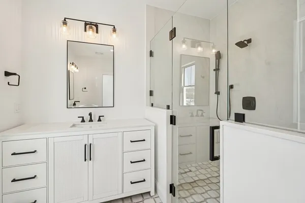 a bathroom with a double vanity sink mirror and shower