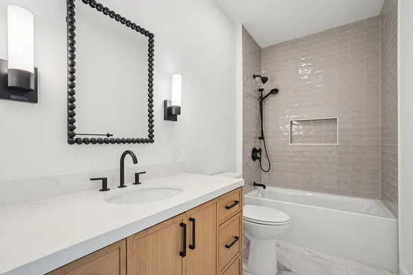 a bathroom with a sink a toilet and shower