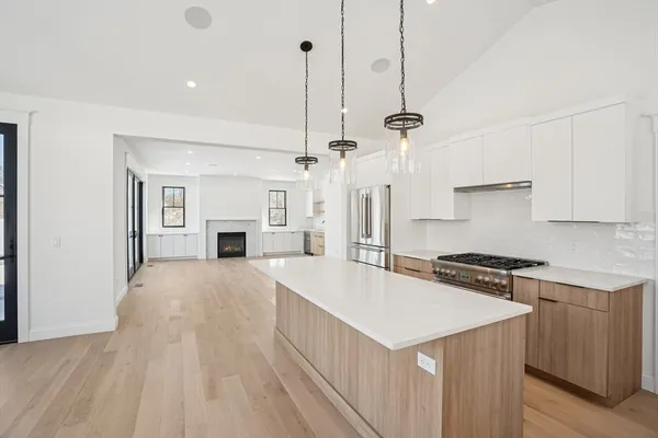 a kitchen with a stove a refrigerator a sink and dishwasher with wooden floor