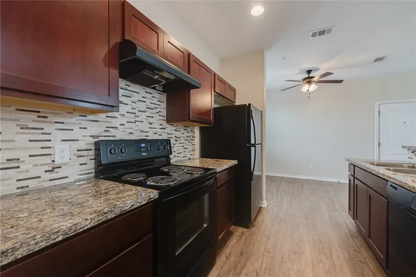 a kitchen with stainless steel appliances granite countertop a stove a refrigerator and a microwave