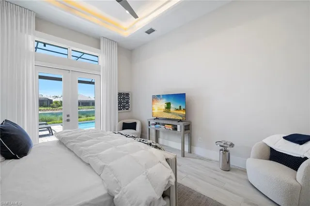 a bedroom with a bed and large windows