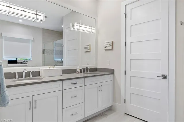 a bathroom with a granite countertop sink double and mirror