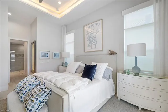 a bedroom with a bed and a lamp on dresser