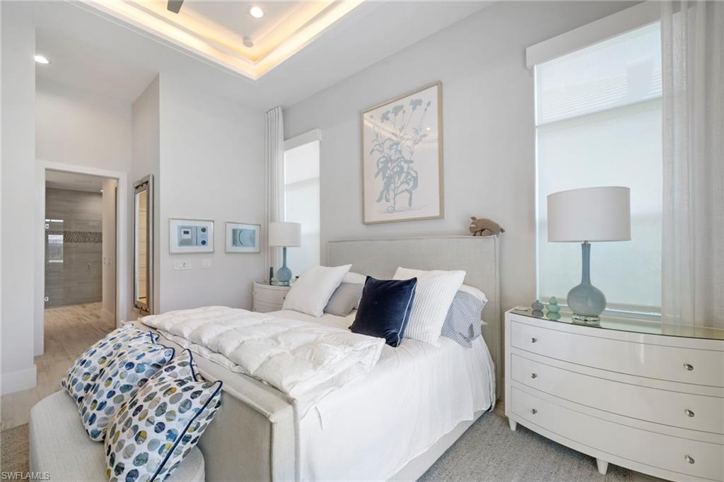 6136 Rodney Bay Lane Naples, FL 34113 - Photo 18 of 29 a bedroom with a bed and a lamp on dresser