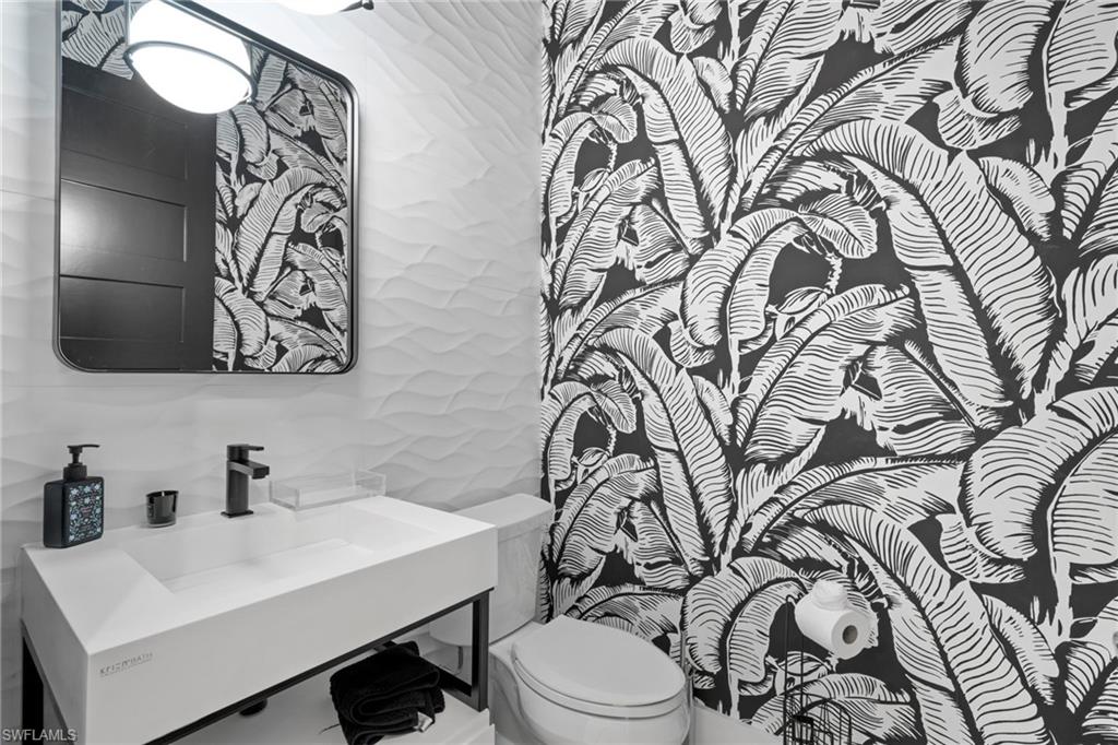 6136 Rodney Bay Lane Naples, FL 34113 - Photo 21 of 29 a bathroom with a toilet sink and mirror