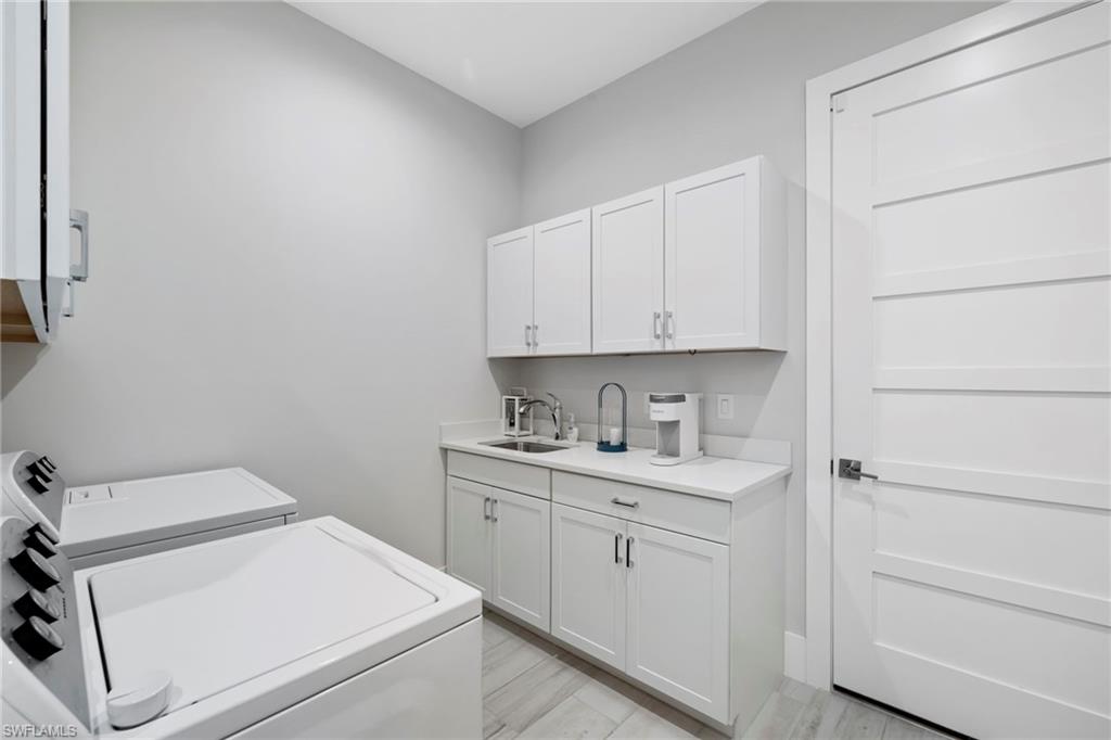 6136 Rodney Bay Lane Naples, FL 34113 - Photo 24 of 29 a view of a room with cabinets and washer