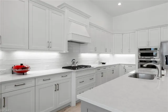 a kitchen with stainless steel appliances white cabinets and a sink