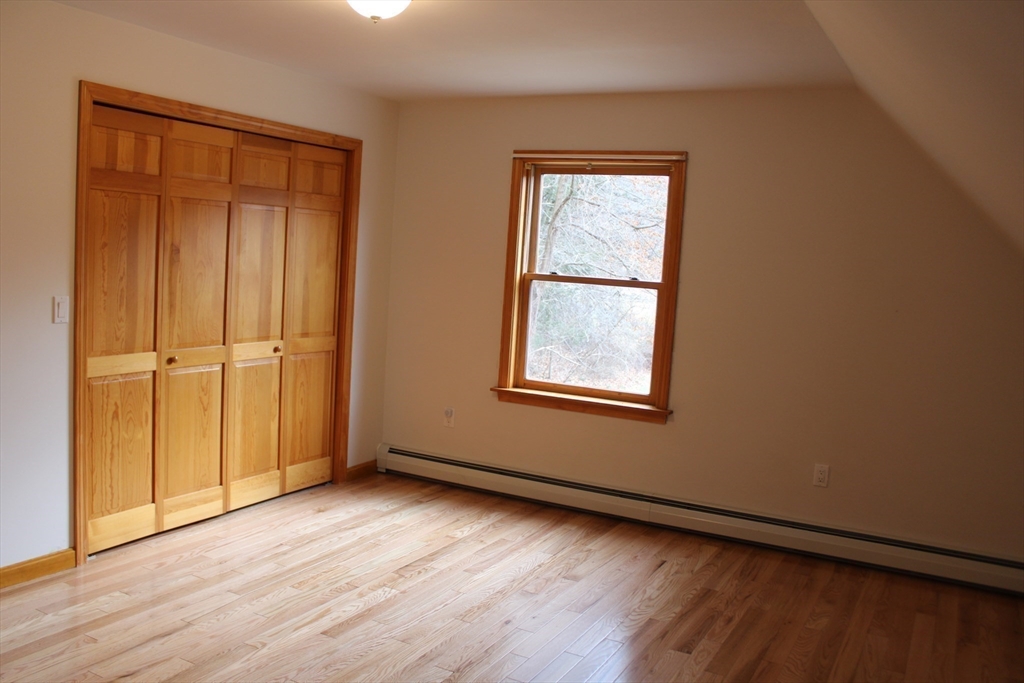 59 Strowbridge Road Northfield, MA 01360 - Photo 17 of 26 an empty room with wooden floor closet and windows