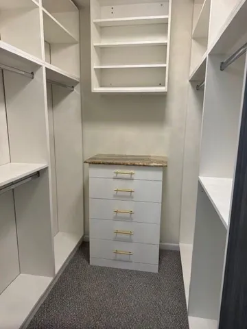 a bathroom with a granite countertop toilet a sink and a mirror
