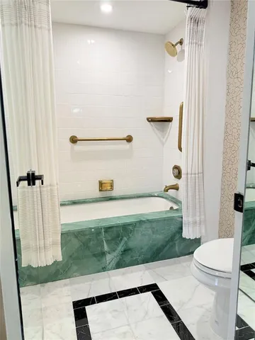 a view of kitchen with kitchen island stainless steel appliances counter space and living room