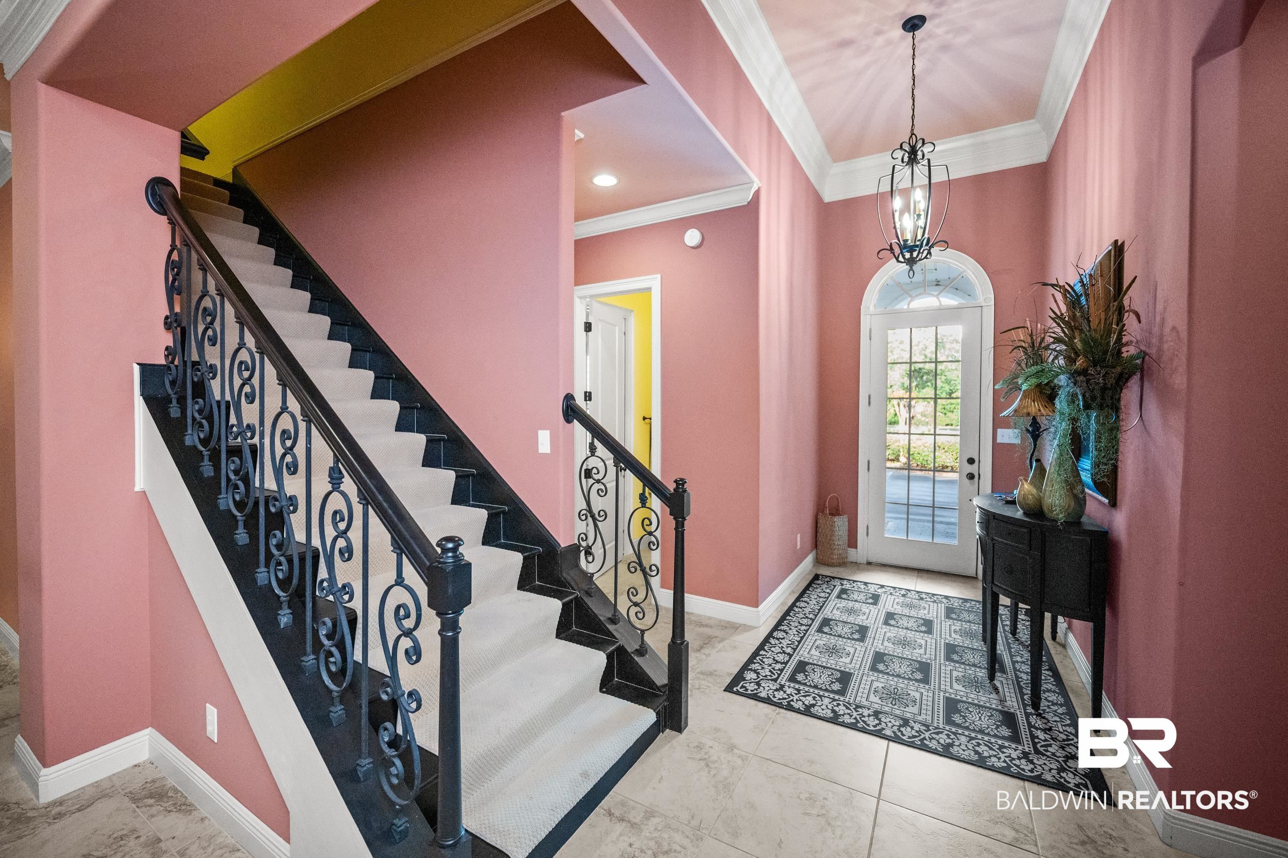404 Peninsula Boulevard Gulf Shores, AL 36542 - Photo 11 of 51 Entrance foyer with crown molding, stairs, a chandelier, and light tile patterned floors