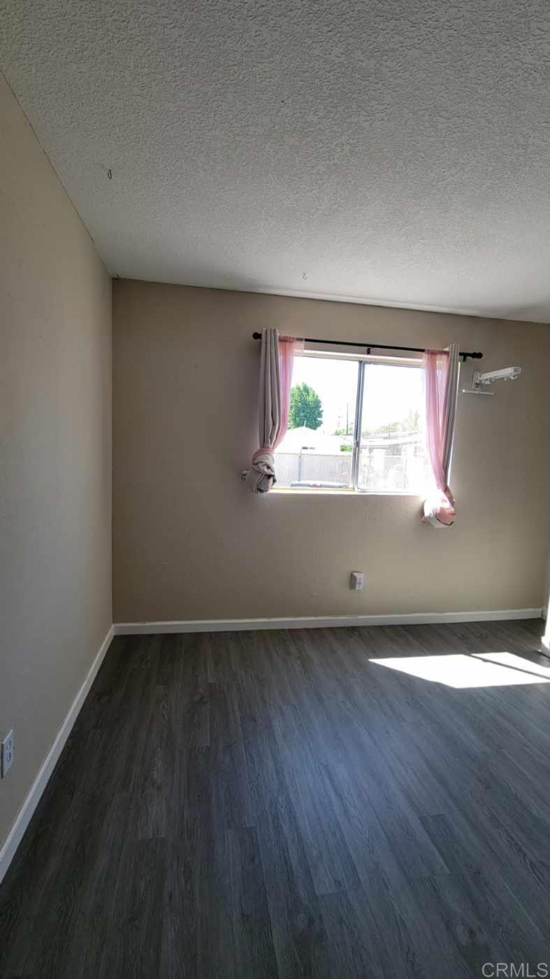 742 A Street, Unit 15 Ramona, CA 92065 - Photo 14 of 18 an empty room with wooden floor and windows