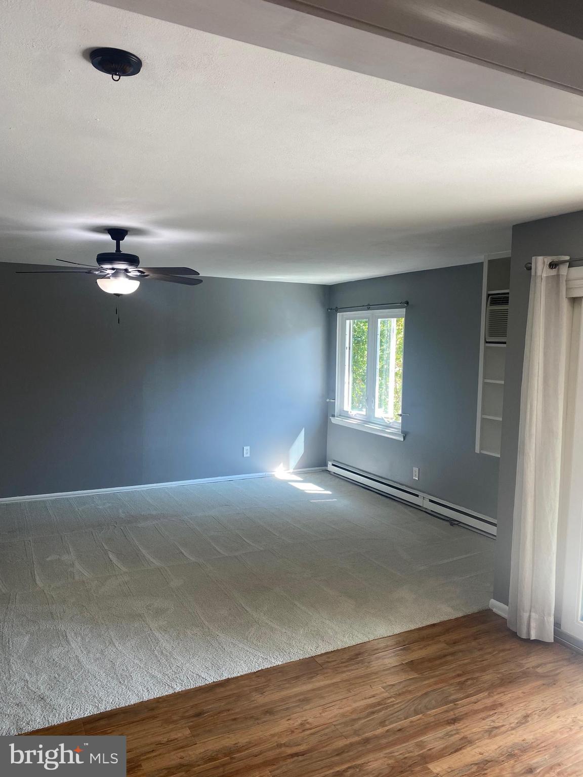 300 Winding Way, Unit B16 Downingtown, PA 19335 - Photo 4 of 21 an empty room with wooden floor chandelier fan and windows