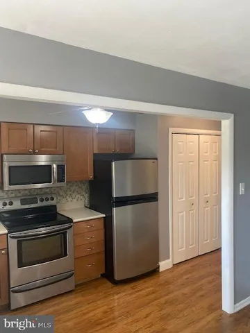 a kitchen with a refrigerator stove and wooden cabinets