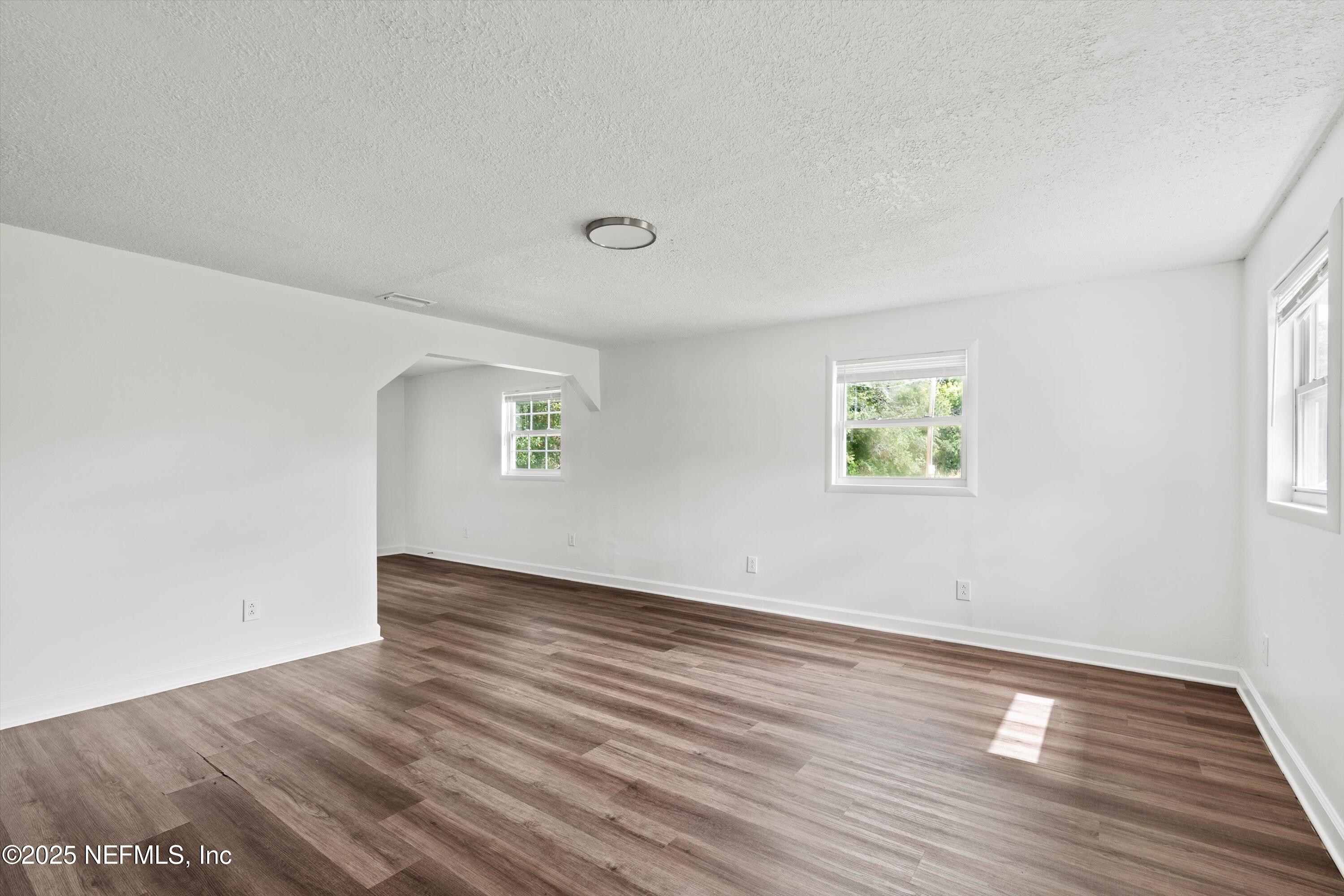 123 Mccallman Road Jacksonville, FL 32218 - Photo 12 of 62 an empty room with wooden floor and windows