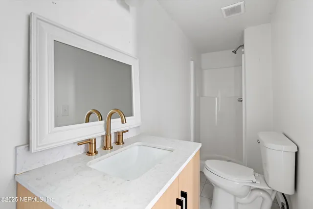 a bathroom with a sink a toilet and a mirror