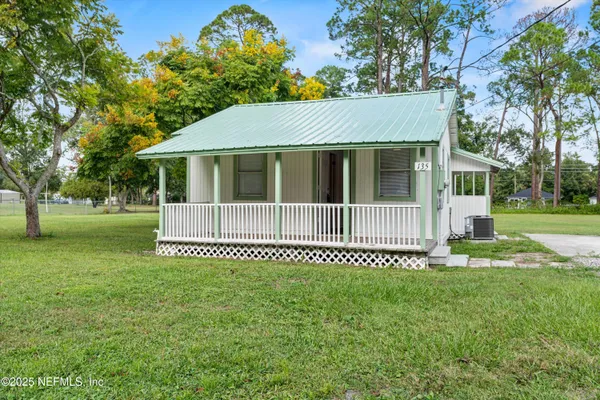 a view of a house with a yard and deck