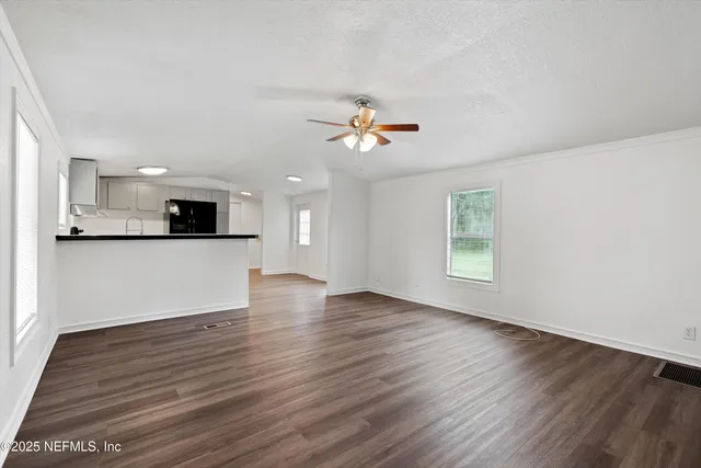 a view of a kitchen with wooden floor and a kitchen
