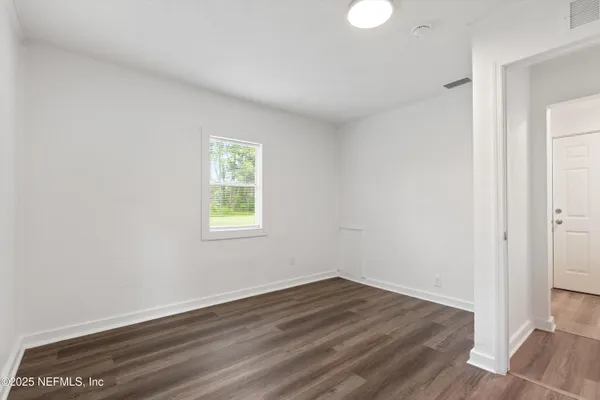 wooden floor in an empty room with a window