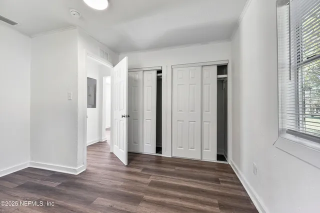 a view of a room with wooden floor and windows in a room