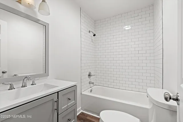 a bathroom with a granite countertop sink toilet and bathtub