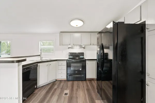 a kitchen with granite countertop a refrigerator stove and sink