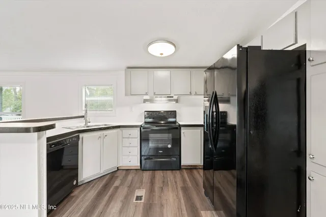 a kitchen with granite countertop a refrigerator stove and sink