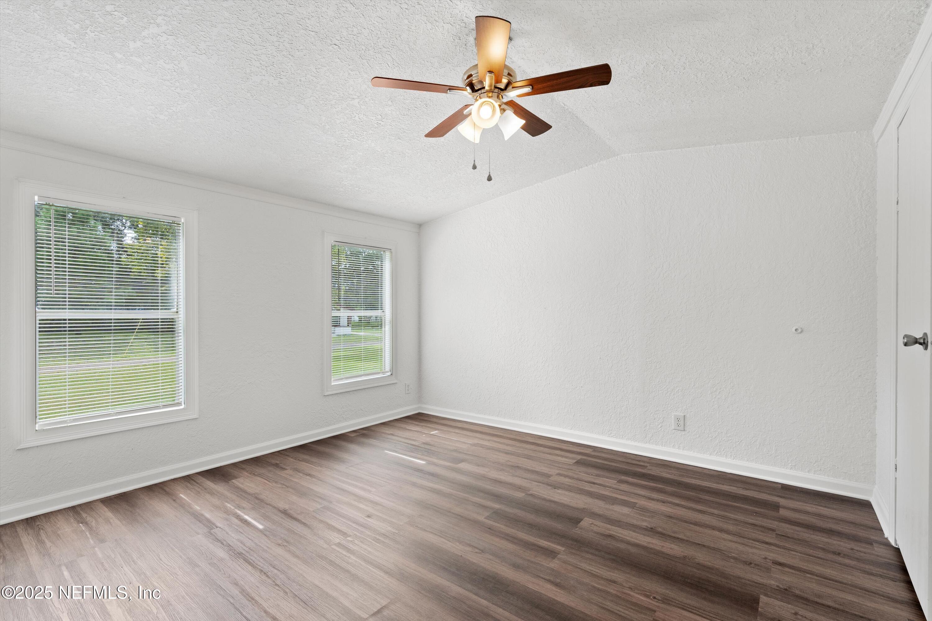 123 Mccallman Road Jacksonville, FL 32218 - Photo 6 of 62 a view of an empty room with wooden floor and a window