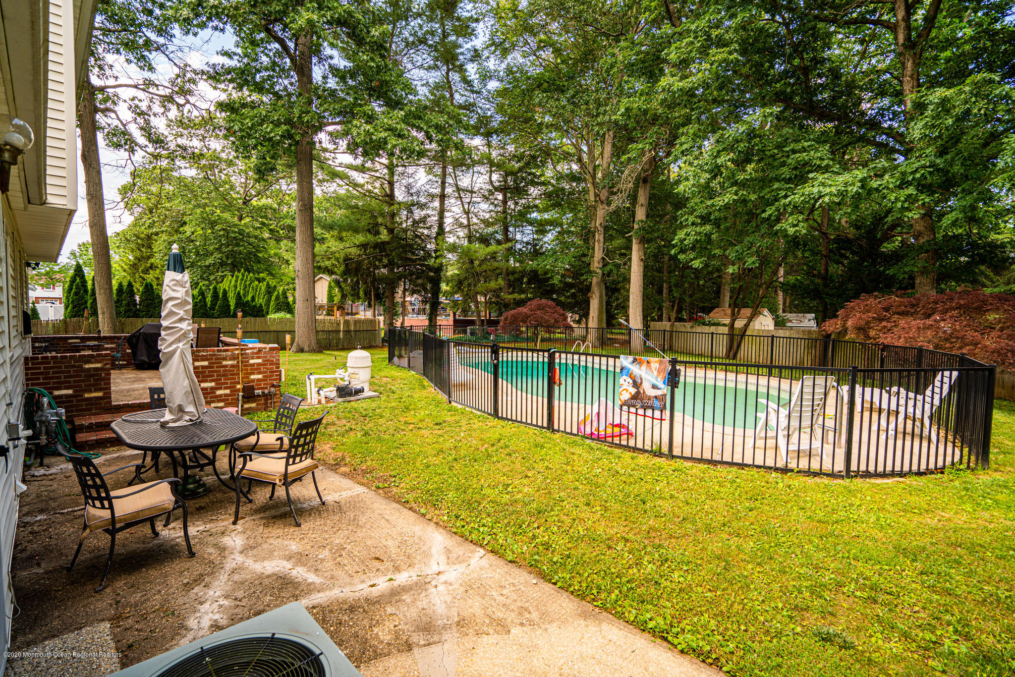 28 Holiday Road Manalapan, NJ 07726 - Photo 17 of 27 a view of a swimming pool with chairs and a small yard