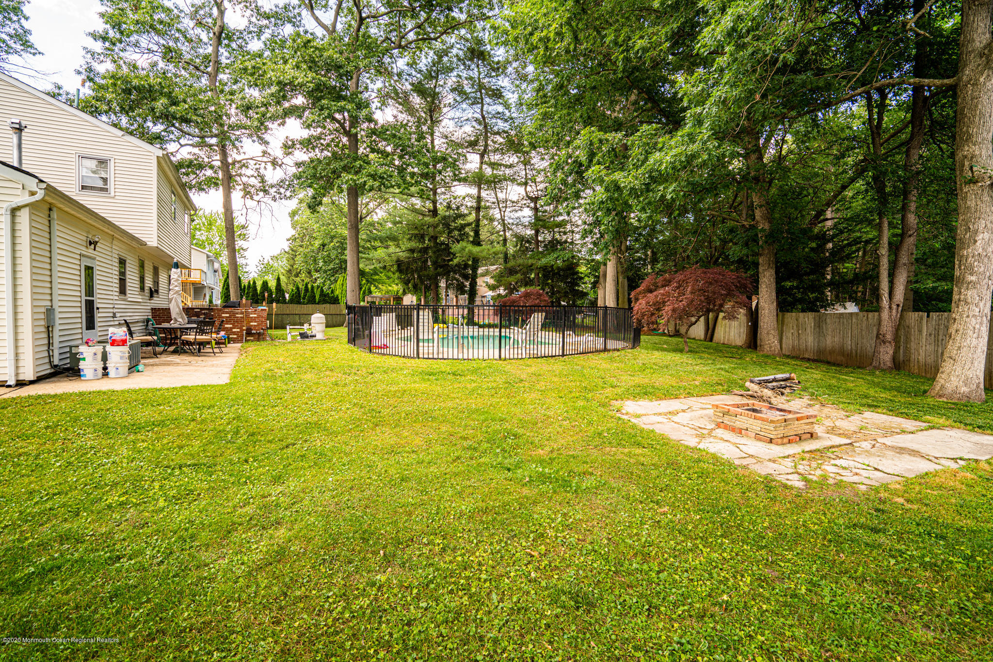 28 Holiday Road Manalapan, NJ 07726 - Photo 20 of 27 a view of a swimming pool with lawn chairs and large trees