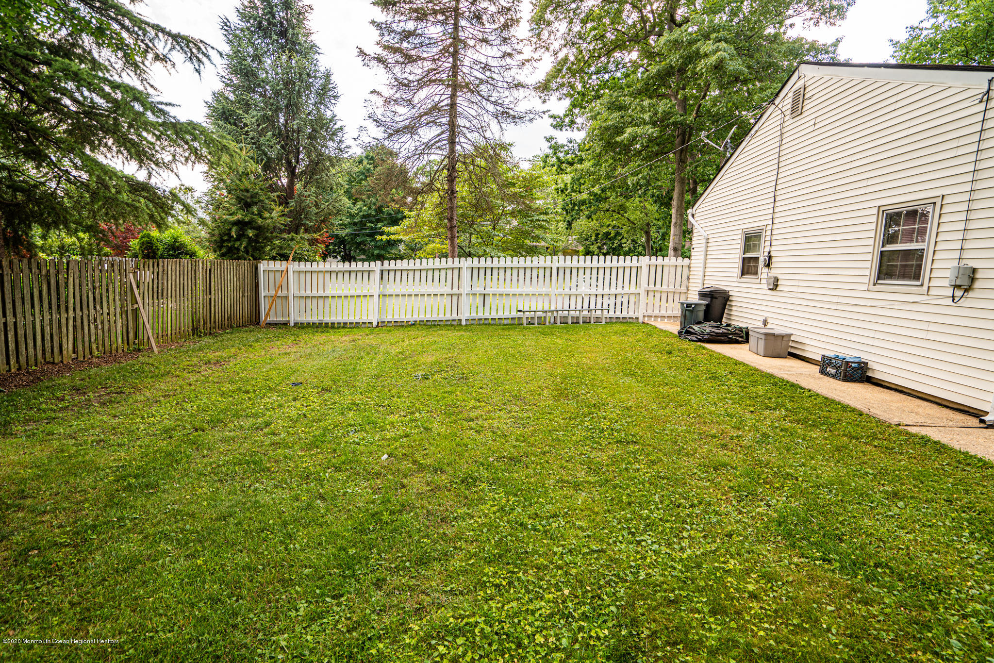 28 Holiday Road Manalapan, NJ 07726 - Photo 24 of 27 a view of a backyard with large trees and wooden fence
