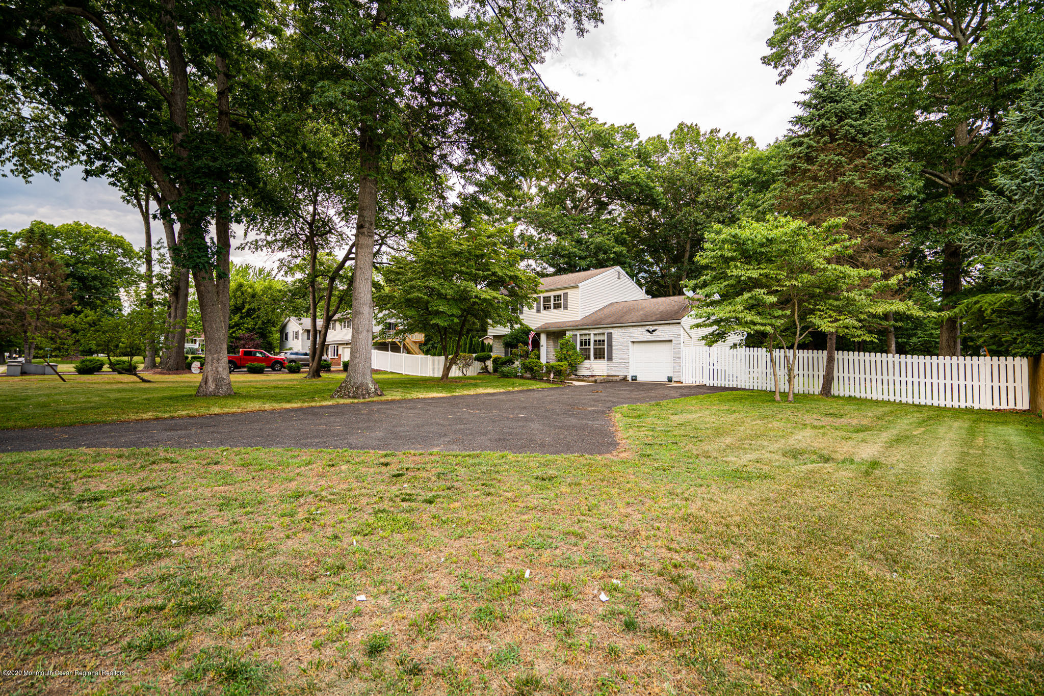 28 Holiday Road Manalapan, NJ 07726 - Photo 25 of 27 a view of swimming pool with lawn chairs and large trees