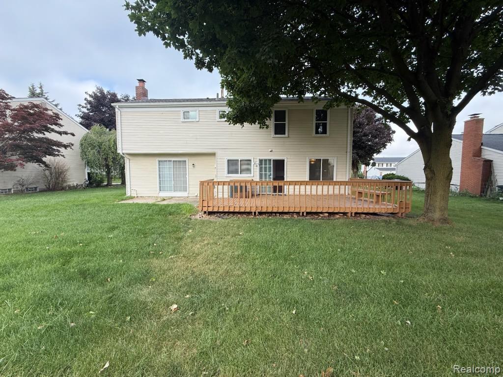 28144 Yorktown Road Farmington, MI 48331 - Photo 25 of 25 Spacious rear yard with a large wooden deck, dual sliding glass doors, and mature trees providing shade